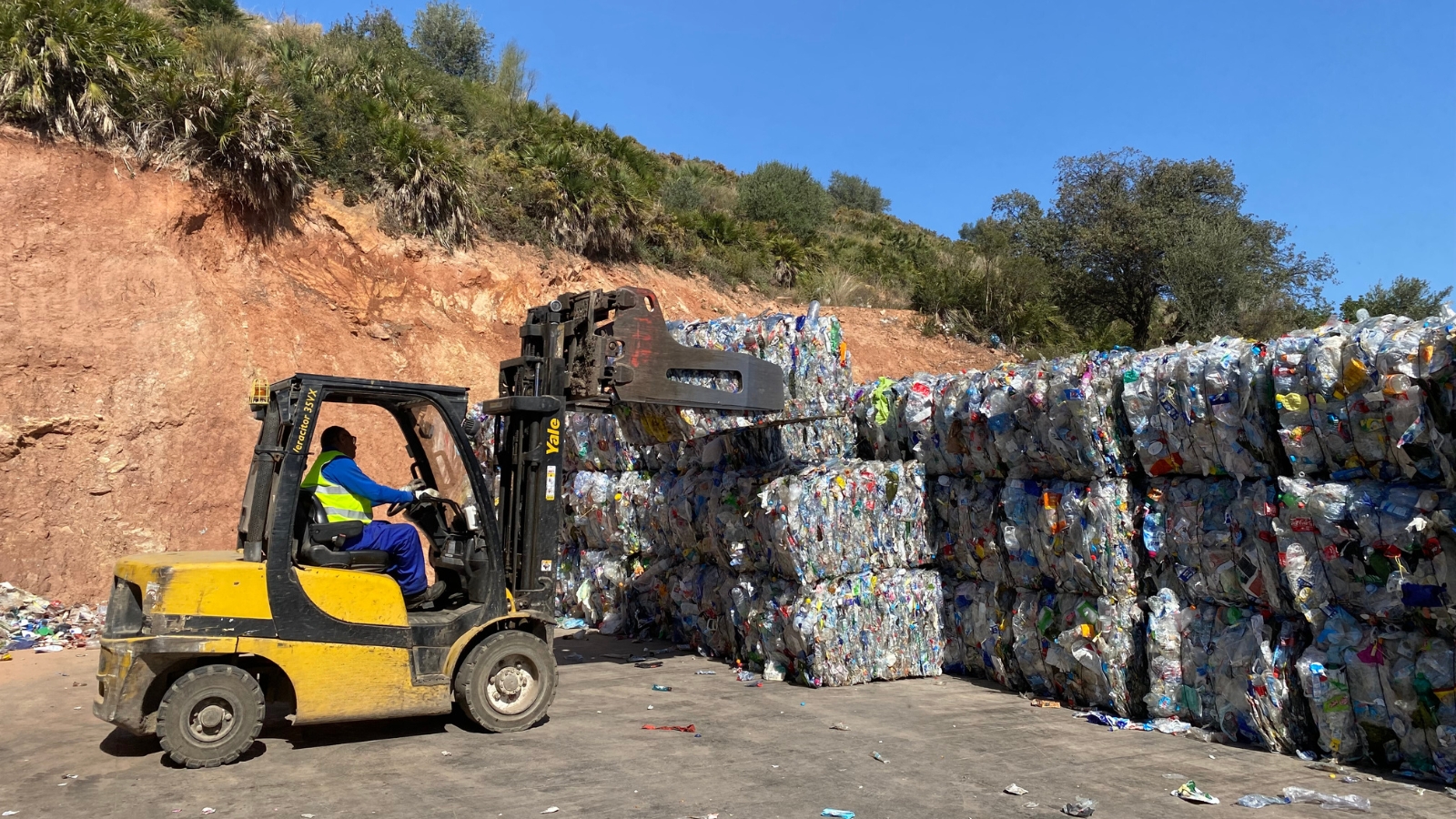 Un trabajador coloca balizas de plástico en el Centro Ambiental de Málaga que recogerá un reciclador